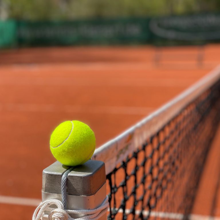 tennis ball on edge of net
